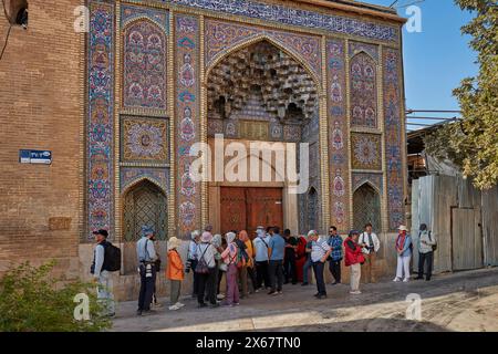 Touristen warten auf die Eröffnung der Nasir al-Mulk Moschee, auch bekannt als die Rosa Moschee, die Moschee aus dem 19. Jahrhundert in Shiraz, Iran. Stockfoto