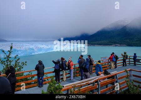 El Calafate, Patagonien, Argentinien, Perito Moreno Gletscher im Los Glaciares Nationalpark. Der Perito-Moreno-Gletscher ist Teil des patagonischen Eisfeldes Campo Hielo Sur, dem drittgrößten Süßwasserreservat der Welt. Touristen stehen auf einer Aussichtsplattform. Stockfoto