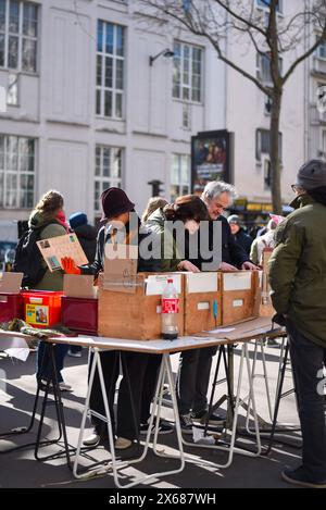 Paris, Frankreich, 02.26.2023 Flohmarkt in Paris. Leute, die sich ein paar Vintage-Platten ansehen. Stockfoto