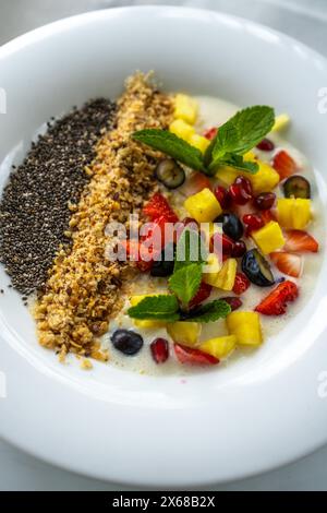 Gesunde Frühstückschüssel, frisches Obst und Beeren, Chia Samen, Müsli, Smoothie Bowl auf einem Tisch Stockfoto