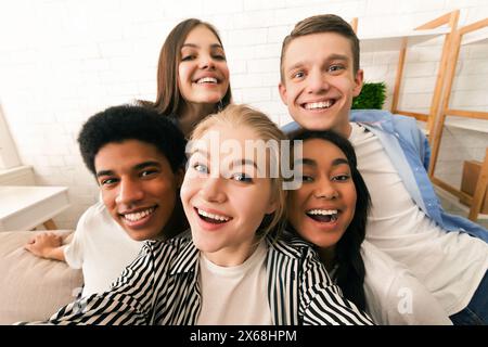 Gruppe glücklicher Freunde, die Selfie zusammen im Wohnzimmer machen Stockfoto