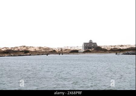 Blick auf die lebensrettende Station Oregon Inlet vom Bonner Bridge Pier vor einem weißen Himmel Stockfoto