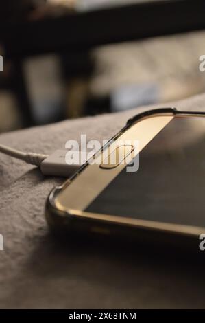 Mobiltelefon an ein Ladegerät angeschlossen Stockfoto