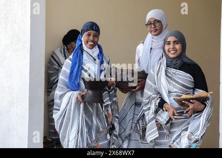 Mogadischu, Somalia. Mai 2024. Menschen, die traditionelle Kleidung tragen, nehmen am 11. Mai 2024 an einer Veranstaltung der Kulturwoche der SIMAD Universität in Mogadischu, Somalia, Teil. Inmitten der lebhaften Farben und rhythmischen Beats auf dem Hauptcampus der SIMAD University tanzte eine Gruppe von Jungen in traditionellem weiß energisch, ihre Bewegungen stimmten mit den Herzklopfen somalischer Volksmusik überein. Die Szene entfaltete sich vor dem Hintergrund traditioneller somalischer Speisen und Pferde im Rahmen der Kulturwoche der Universität, die am Samstag begann. Quelle: Hassan Bashi/Xinhua/Alamy Live News Stockfoto