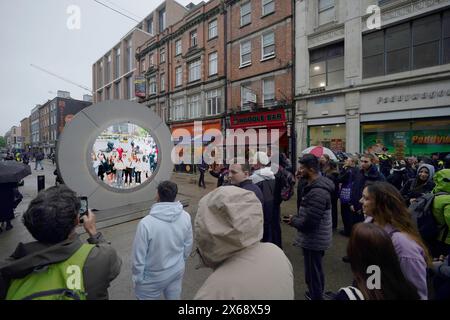 Die Menschen sehen das Live-Stream-Portal zwischen Dublin und New York, das aufgrund eines "unangemessenen Verhaltens" in der irischen Hauptstadt vorübergehend geschlossen wurde, was zu Veränderungen in der Funktionsweise der visuellen Verbindung geführt hat. Tausende von Menschen haben das bidirektionale Live-Stream-Portal besucht, das einen Echtzeitblick auf New York bietet. Der Fluss 24/7 liegt im Norden Dublins, gegenüber der O’Connell Street, während die amerikanische Anlage an der North Earl Street liegt. Ausgabedatum: Montag, 13. Mai 2024. Stockfoto