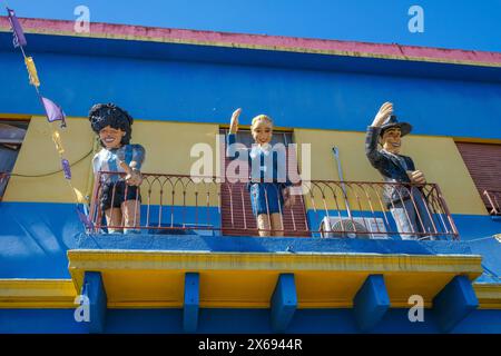 La Boca, Buenos Aires, Argentinien - La Boca, bunt bemalte Häuser im Hafenviertel rund um die El Caminito Gasse. Auf einem Balkon über einem Laden begrüßen Sie die Figuren des legendären Fußballers Diego Maradona, der Politikerin First Lady Eva Peron und des Tangosängers Carlos Gardel Stockfoto