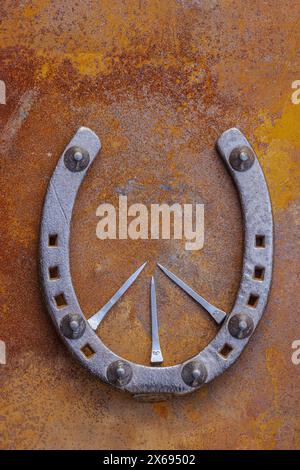 Altes Hufeisen als Dekoration, Glückssymbol auf rostigem Hintergrund Stockfoto