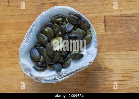 Kürbiskerne, Muschelschale als Schüssel, Stillleben Stockfoto