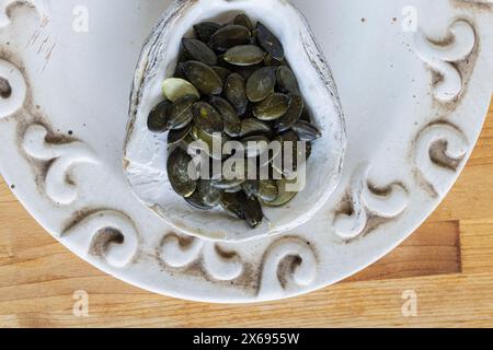 Kürbiskerne, Muschelschale als Schüssel, Stillleben Stockfoto