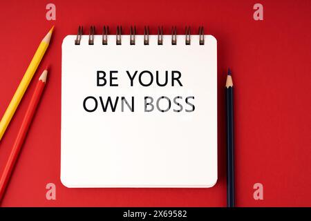 Text „Be your own Boss“ auf rotem Hintergrund des Notizblocks Stockfoto