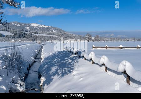 Sonthofen - Altstädten, Winterlandschaft im Illertal, welliger schneebedeckter Zaun am Fischbach Stockfoto