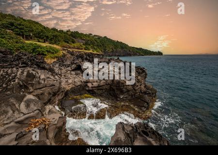 Natur in einer besonderen Landschaft. Eine felsige Küste am Meer. Großartige Landschaft mit Klippen in der Karibik, die Wellen stürzen gegen die Insel Guadeloupe auf den französischen Antillen. Stockfoto