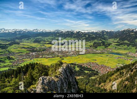 Frühling in den Bergen. Blick von den Grünten ins Illertal bei Sonthofen. Wiesen, Wälder und schneebedeckte Berge unter blauem Himmel. Allgäuer Alpen, Bayern, Deutschland Stockfoto