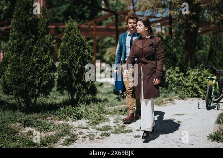 Geschäftsleute, die während einer Pause in einem üppigen Park spazieren gehen Stockfoto