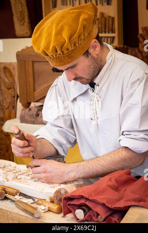 Ein Holzhandwerker, der seine Arbeit während des mittelalterlichen Markts in der Stadt El Álamo (Madrid), Spanien, am 4. Mai 2024 probiert Stockfoto