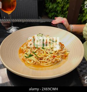 Teller mit Krabbenlinguine garniert mit Petersilie und Parmesankäse. Stockfoto