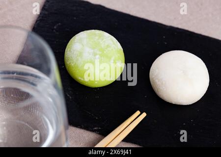 Japanisches Mochi-Eis auf Schieferbrett mit Essstäbchen Stockfoto