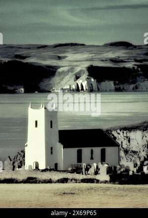 Ballintoy Pfarrkirche in Ballintoy Harbour in der Nähe von Bushmills an County Antrim Coast Road. Rathlin Insel hinter. Nordirland Stockfoto