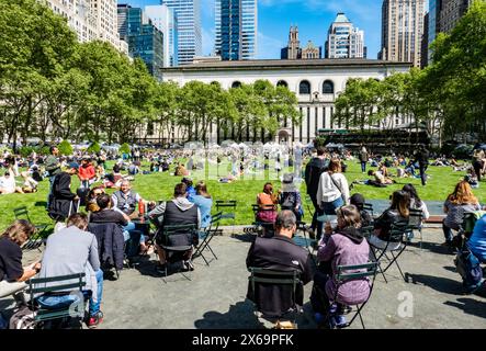 Touristen und New Yorker genießen die urbane Oase Bryant Park in Midtown Manhattan an einem sonnigen Frühlingstag, 2024, New York City, USA Stockfoto