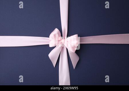 Pinkes Satinband mit Schleife auf blauem Hintergrund, Draufsicht Stockfoto