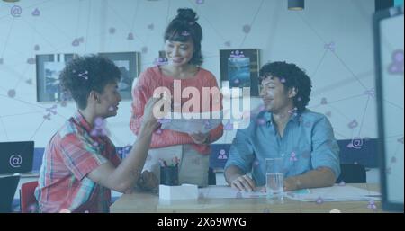 Bild von Symbolen, die mit Linien über verschiedenen Kollegen verbunden sind, die Berichte am Schreibtisch diskutieren Stockfoto