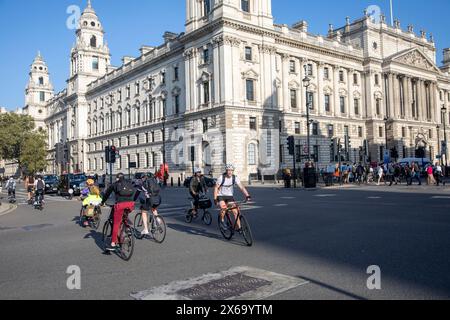 Fahrradfahren in London, Radfahrer fahren auf dem Parliament Square Westminster Central London am sonnigen Herbstmontag am blauen Himmel, England, UK, 2023 Stockfoto