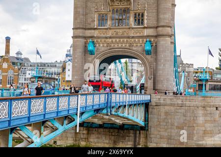 Fußgänger gehen über die Tower Bridge, vorbei an einem roten Londoner Doppeldeckerbus, London, England, UK, 2023 Stockfoto