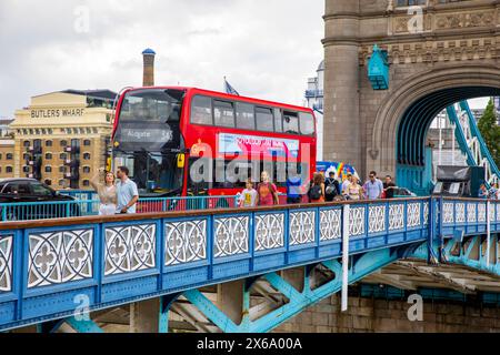 Tower Bridge London berühmtes Wahrzeichen, Wanderer Touristen überqueren die Brücke neben dem Londoner Doppeldeckerbus in Richtung Aldgate, London, England, Großbritannien Stockfoto