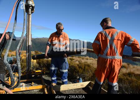 HAUPIRI, NEUSEELAND, 7. MAI 2024: Bohrer betreiben ein tragbares Bohrgerät, um ein 10 Meter langes Loch auf dem Gipfel des Mount Morgan mit Blick auf das Haupiri Valley an der Westküste Neuseelands zu versenken. Das Loch wird für seismische GPS-Überwachungsinstrumente verwendet, um die Bewegung entlang der Alpenverwerfung zu messen, die sich in der Nähe des Berges befindet. Die gesamte Bohrausrüstung einschließlich Luftkompressor, Generator und Bohrgerät wurde per Hubschrauber zum Gipfel geflogen. Stockfoto