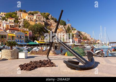 Der große Anker ist eine malerische Szene mit Yachthafen und farbenfrohen Gebäuden auf der Insel Symi, Griechenland Stockfoto