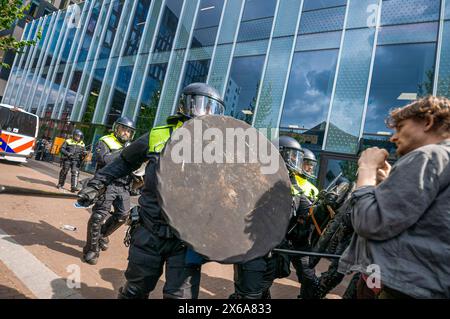 Polizeibeamte verwenden Schlagstöcke mit Gewalt, um Studenten-Demonstranten außerhalb des Universitätsgeländes während der Kundgebung zu zerstreuen. Studentenprotestierende und ihre Unterstützer besetzten kurzzeitig die Universität Amsterdam auf dem Campus Roeterseiland im Zentrum von Amsterdam, die Polizei setzte extrem harte Gewalt ein, um die große Studentenschaft zu zerstreuen. Die Demonstranten wollen, dass die Universität alle Verbindungen zu israelischen Institutionen abbaut, um das Volk des Gazastreifens und den anhaltenden Völkermord an seinem Volk durch die israelische Verteidigungsstreitkräfte (IDF) zu unterstützen. Stockfoto