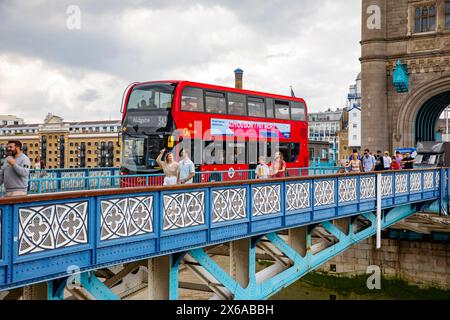 Tower Bridge London berühmtes Wahrzeichen, Wanderer Touristen überqueren die Brücke neben dem Londoner Doppeldeckerbus in Richtung Aldgate, London, England, Großbritannien Stockfoto