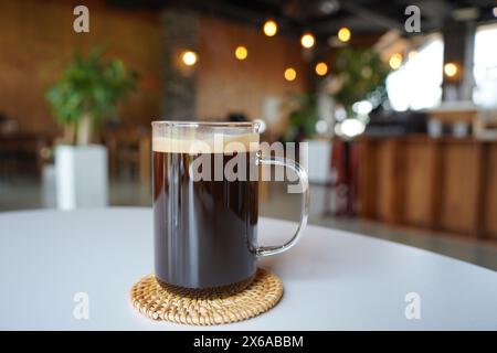 Kaffee in einem Glas mit Bokeh im Hintergrund Stockfoto