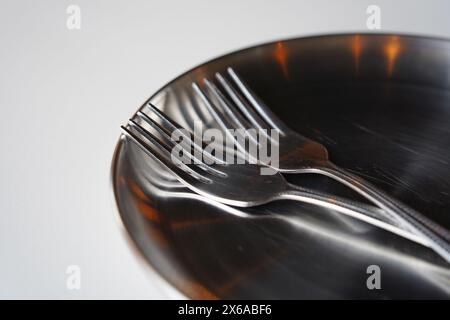 Edelstahlplatte und Gabel auf weißem Tisch Stockfoto