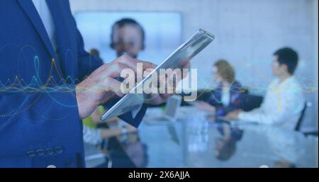 Bild der Datenverarbeitung im mittleren Bereich eines Geschäftsmannes mit digitalem Tablet im Büro Stockfoto