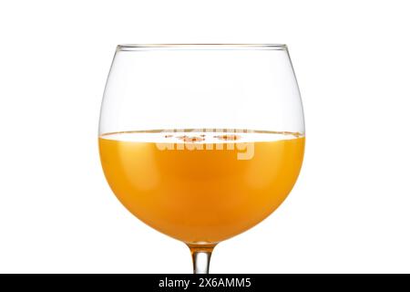 Extreme Nahaufnahme von Orangensaft in einem Ballonglas isoliert auf weißem Hintergrund. Stockfoto