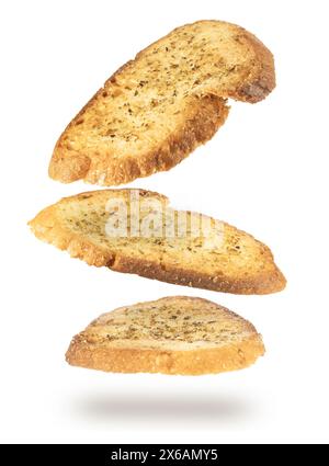 Fallende Scheiben von gewürztem und knusprigem Brot, Bruschetta-Stil, isoliert auf weißem Hintergrund. Stockfoto