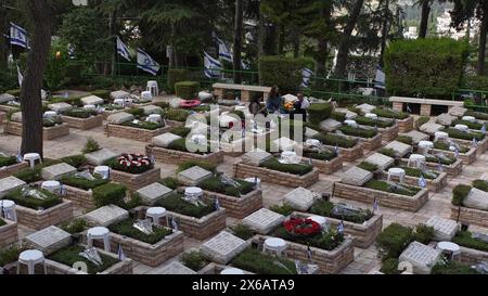 JERUSALEM – 12. MAI: Israelische Nationalflaggen mit schwarzen Trauerbändern sitzen über den Gräbern der gefallenen israelischen Soldaten auf dem nationalen Militärfriedhof in Mount Herzl, während sich das Land auf den Gedenktag des Yom Hazikaron für die gefallenen Soldaten am 12. Mai 2024 in Jerusalem vorbereitet. Israel Stockfoto