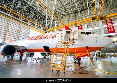 (240514) -- HAIKOU, 14. Mai 2024 (Xinhua) -- Mitarbeiter von Grand China Aviation Maintenance Co., Ltd. (GCAM) unterhalten ein einreichendes Flugzeug in einem Hangar einer Flugzeugwartungsbasis in Haikou, südchinesischer Provinz Hainan, 13. Mai 2024. Eine Boeing 737-800-Maschine der südkoreanischen Jeju Air wurde kürzlich von der GCAM gewartet, die auch die Erstaufstellung für die Wartung von eingehenden Flugzeugen aus Südkorea im Freihandelshafen Hainan ist. Der Dienst wird voraussichtlich etwa 16 Tage dauern und für den Freihandelshafen Präferenzbehandlung einschließlich Befreiung von Bargeldeinlagen in Betracht kommen Stockfoto