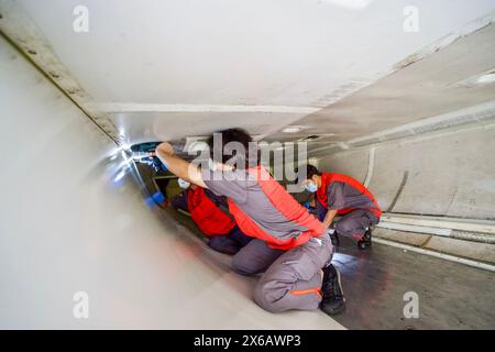 (240514) -- HAIKOU, 14. Mai 2024 (Xinhua) -- Mitarbeiter von Grand China Aviation Maintenance Co., Ltd. (GCAM) arbeiten im Frachtraum eines eingehenden Flugzeugs in einem Hangar einer Flugzeugwartungsbasis in Haikou, südchinesischer Provinz Hainan, 13. Mai 2024. Eine Boeing 737-800-Maschine der südkoreanischen Jeju Air wurde kürzlich von der GCAM gewartet, die auch die Erstaufstellung für die Wartung von eingehenden Flugzeugen aus Südkorea im Freihandelshafen Hainan ist. Der Service wird voraussichtlich etwa 16 Tage dauern, wobei die Präferenzbehandlung des Freihandelhafens einschließlich EXE gewährt werden kann Stockfoto