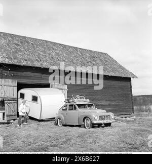 Caravan in den 1950ern Eine Familie hat ihren Wohnwagen im Winter in der Scheune geparkt und es ist an der Zeit, den Wohnwagen für den Sommerurlaub zu nutzen. Das Auto ist ein Volvo PV. Conard Ref. 3722 *** örtlicher Bildtitel *** Husvagnen kan vara föregångaren till husvagnen Ägget som lanserades 1955. DET första beispiellaret av den husvagnen byggdes 1948 byggdes på initiativ av Helmer Berglund i Örebro på hans eget företag SMV, Sörby Mekaniska Verkstad. Han och hustrun kunde inte enas om hur de Skulle fira sin Semester men han bestämde sig för att göra en husvagn. EN kompromiss mellan fruns önskan om en Stockfoto