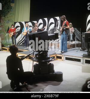 Mode der 1970er Jahre Ein junger Mann, der die typische Mode der 1970er Jahre trägt, eine Hose mit breiten Beinen. Eine Hose mit dem Namen Bell-Bottoms oder Flares, die von den Knien bis nach unten breiter wird und eine glockenartige Form des Hosenbeins bildet. Er ist Musiker Claes af Geijerstam mit seiner Band Marsfolket in einem tv-Studio und nimmt ein Programm auf. 1971. Svahn Stockfoto