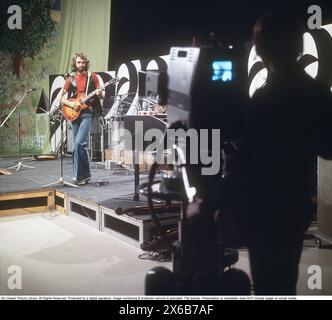 Mode der 1970er Jahre Ein junger Mann, der die typische Mode der 1970er Jahre trägt, eine Hose mit breiten Beinen. Eine Hose mit dem Namen Bell-Bottoms oder Flares, die von den Knien bis nach unten breiter wird und eine glockenartige Form des Hosenbeins bildet. Er ist Musiker Claes af Geijerstam mit seiner Band Marsfolket in einem tv-Studio und nimmt ein Programm auf. 1971. Svahn Stockfoto