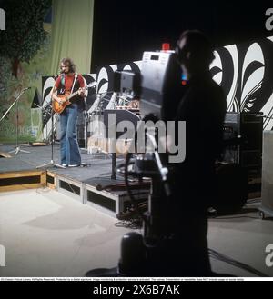 Mode der 1970er Jahre Ein junger Mann, der die typische Mode der 1970er Jahre trägt, eine Hose mit breiten Beinen. Eine Hose mit dem Namen Bell-Bottoms oder Flares, die von den Knien bis nach unten breiter wird und eine glockenartige Form des Hosenbeins bildet. Er ist Musiker Claes af Geijerstam mit seiner Band Marsfolket in einem tv-Studio und nimmt ein Programm auf. 1971. Svahn Stockfoto