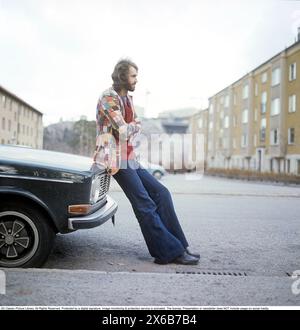 Mode der 1970er Jahre Ein junger Mann, der die typische Mode der 1970er Jahre trägt, eine Hose mit breiten Beinen. Eine Hose mit dem Namen Bell-Bottoms oder Flares, die von den Knien bis nach unten breiter wird und eine glockenartige Form des Hosenbeins bildet. Er ist der Musiker Claes af Geijerstam. 1971. Svahn Stockfoto