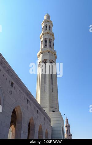 Ein hoch aufragendes Minarett steht in eleganter Pracht vor dem klaren blauen Himmel und zeigt komplexe architektonische Details. Stockfoto