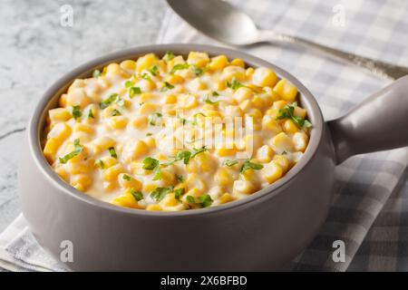 Hausgemachte Slow Cooker Creamed Corn in a Bowl Closeup auf der Schüssel auf dem Tisch. Horizontal Stockfoto