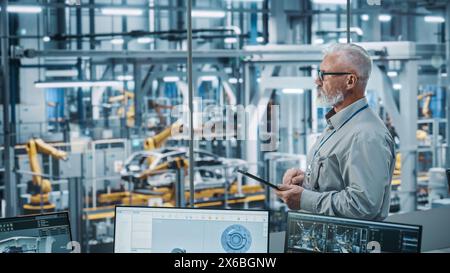 Autowerkstatt: Porträt eines leitenden weißen männlichen Chefingenieurs mit Tablet-Computer in automatisierten Roboterarmmontagestraßen zur Herstellung von High-Tech-Elektrofahrzeugen. Seitenansicht Stockfoto