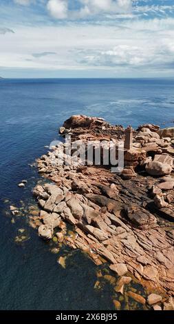 Drohnenaufnahmen des Phare de Men Ruz Ploumanac'h Perros-Guirec Frankreich, des ikonischen rosa Granit-Leuchtturms, der auf zerklüfteten Felsformationen thront Stockfoto