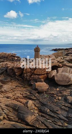 Drohnenaufnahmen des Phare de Men Ruz Ploumanac'h Perros-Guirec Frankreich, des ikonischen rosa Granit-Leuchtturms, der auf zerklüfteten Felsformationen thront Stockfoto